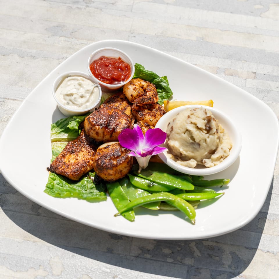 Grilled scallops, shrimp, and fish with mashed potatoes, snap peas, and dipping sauces.